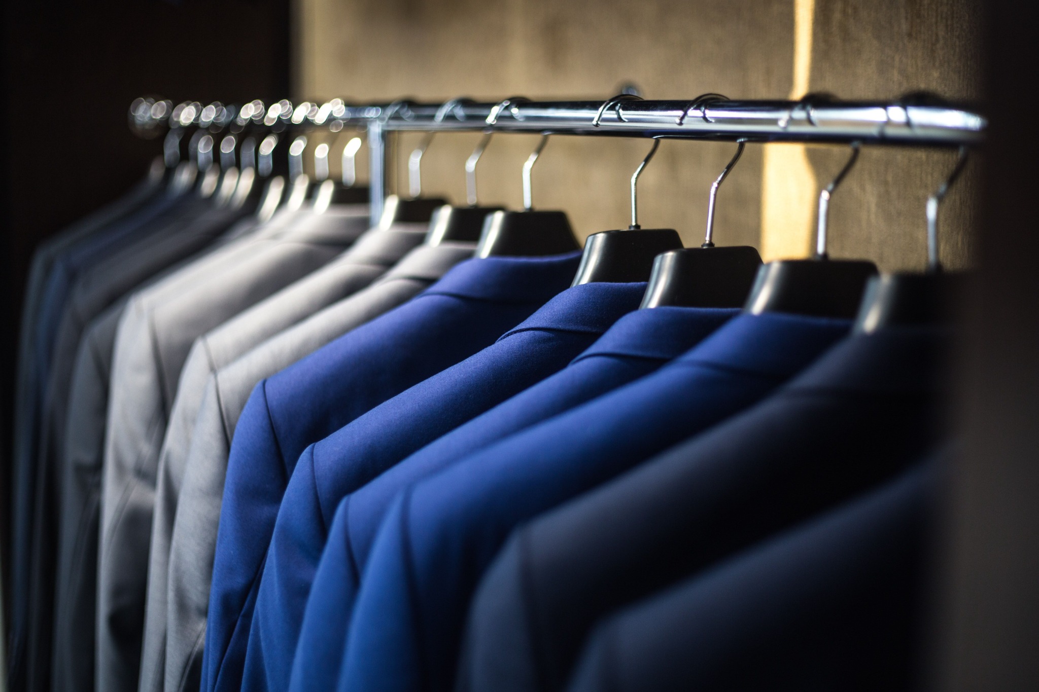 Rail of blue, navy and grey suit jackets on hangers